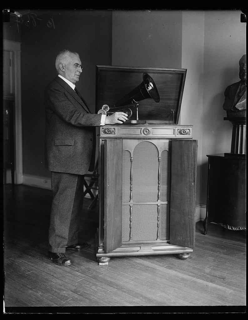 In 1927, Berliner posed with an early phonograph and a Victor Victrola Credenza. Photograph by Harris & Ewing, Library of Congress.