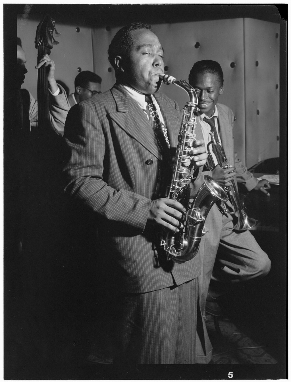 The Three Deuces club on 52nd Street, New York, 1947: Charlie Parker (center) on alto saxophone, with Miles Davis (right) holding his trumpet. Photo by William P. Gottlieb, Library of Congress, public domain.